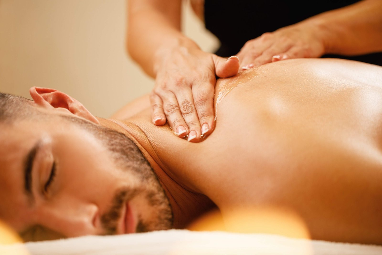 Closeup man enjoying relaxing back massage with honey spa scaled e1686860970475